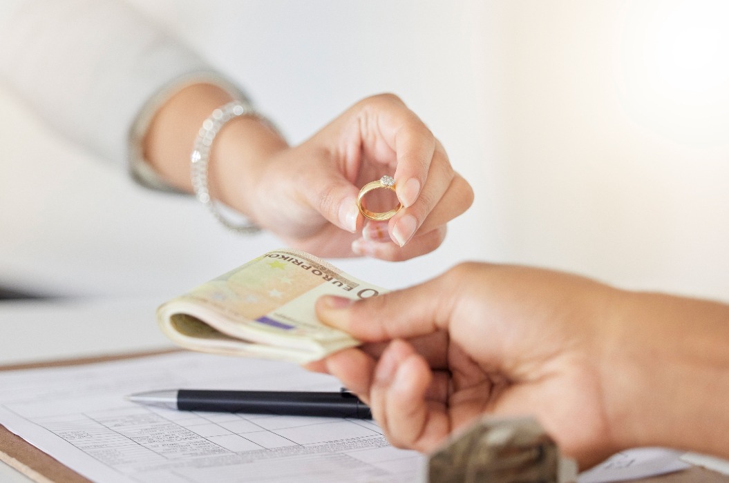 .Geldwechsel, Bewertung und Verkauf von Goldringen und Diamanten für eine Frau mit Studienkreditschulden. Schmuckverkäufer, Geld- und Goldschmiedegeschäft in einem Pfandhaus für eine insolvente Person mit Kreditraten.